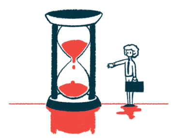 A woman stands next to an hourglass.